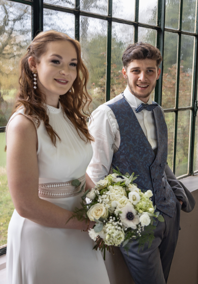 Photo de mariées devant une verrière.